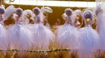Feathered angel decorations hanging on display.