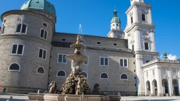 Barockbrunnen vor historischem Gebäude.
