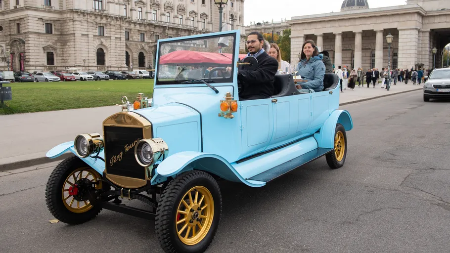 Vintage car driving on city street.