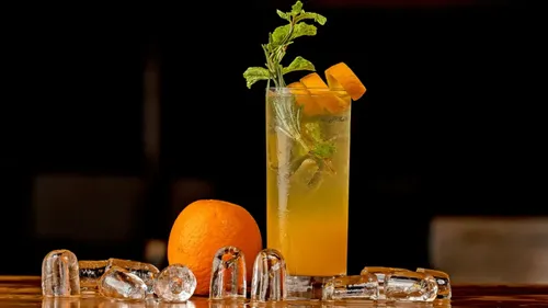 Orangencocktail auf Tisch mit Eiswürfeln.