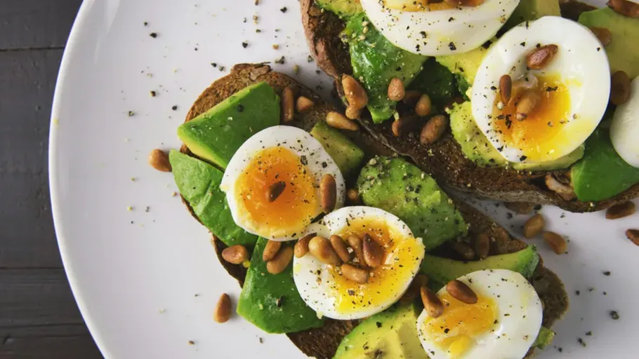 Avocado toast with eggs and pine nuts.