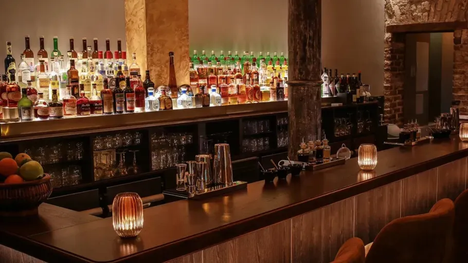 Bar counter with drinks, dimly lit ambiance.