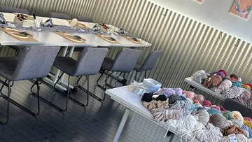 Bastel-Workshop-Tische mit Garn und Materialien.