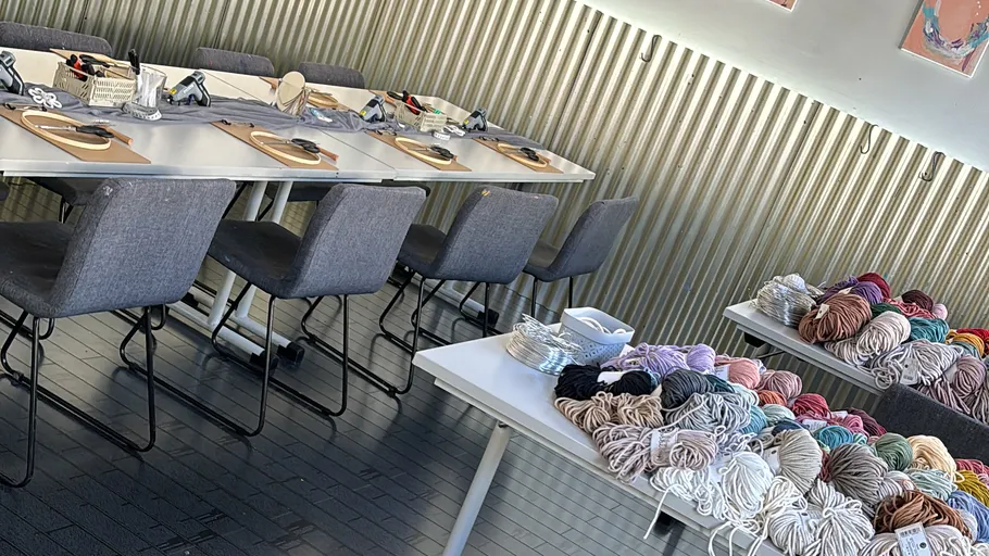Craft workshop tables with yarn and supplies.