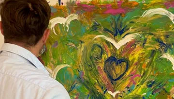 Person painting colorful abstract artwork.