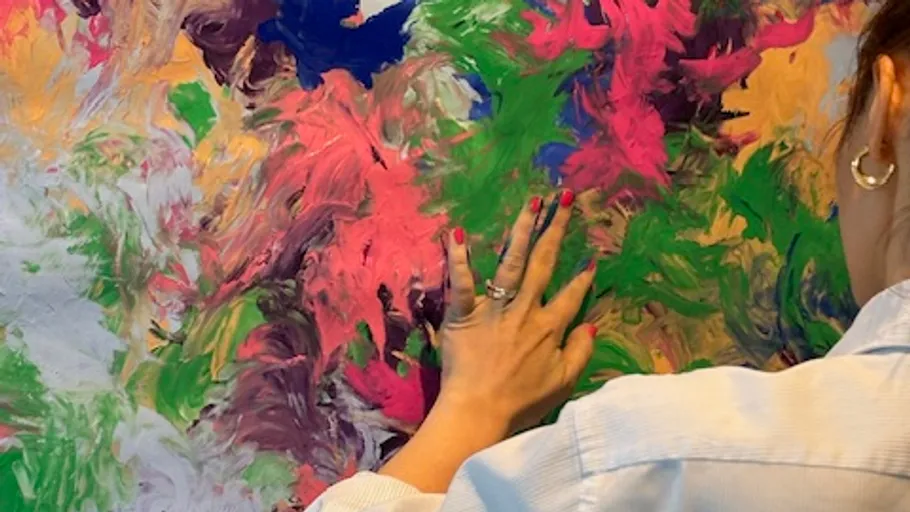 Person painting abstract art with hands.