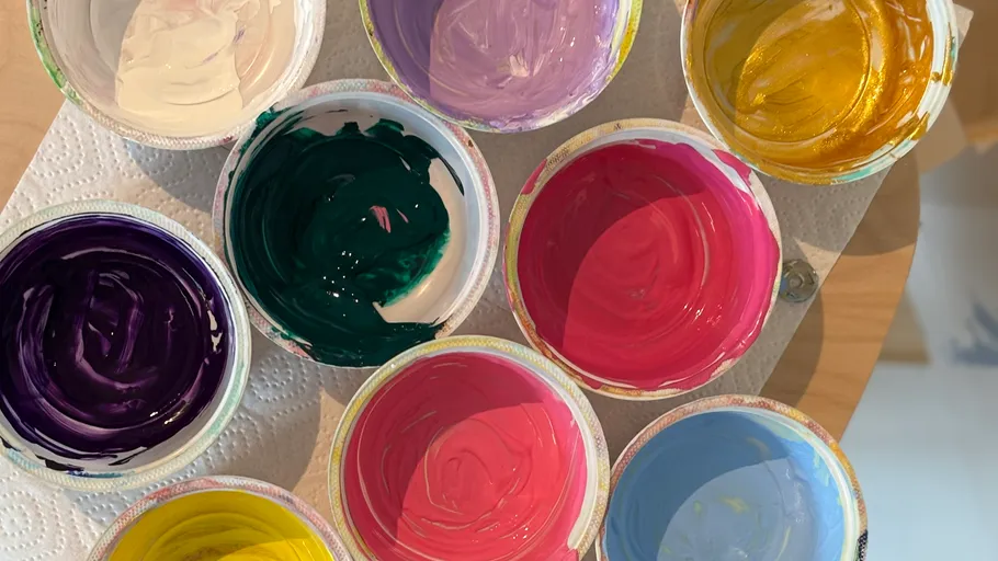 Colorful paint pots arranged on a table.