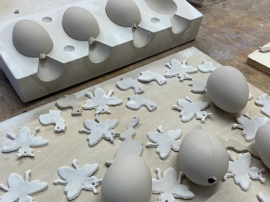Clay eggs and shapes on a wooden table.