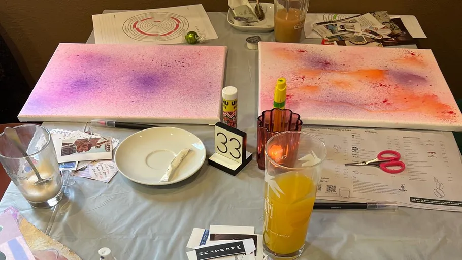 Kunstbedarf auf Tisch mit bunten Leinwänden.