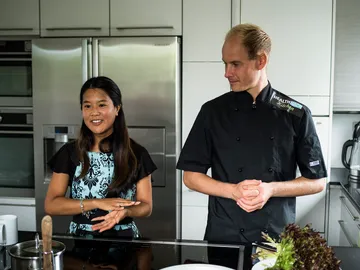 Zwei Personen sprechen in einer modernen Küche über Kochen.