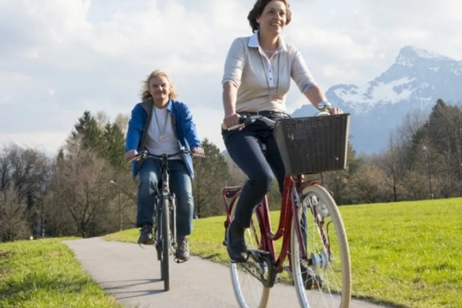 Two people cycling on a scenic path.