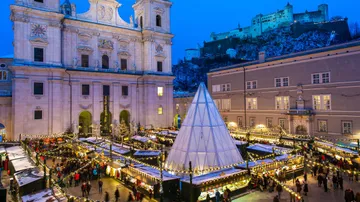 Christmas market with stalls in snowy square.
