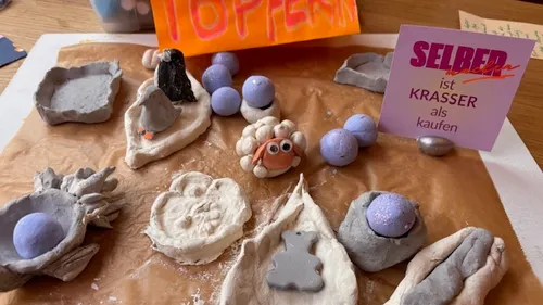 Tonkreationen auf Papier mit buntem Schild.