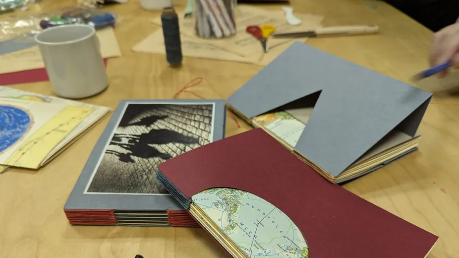 Handgemachte Journale und Bastelmaterialien auf Tisch.