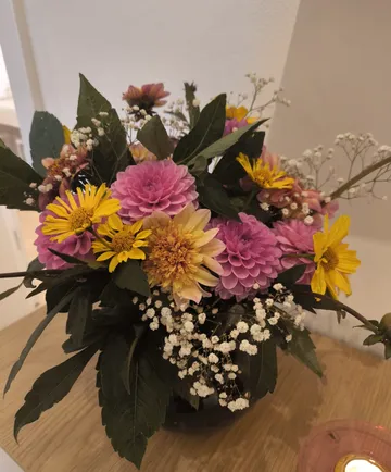 Bunter Blumenstrauß auf einem Holztisch.