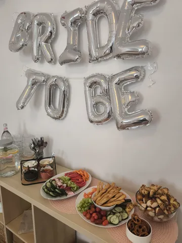 Party-Setup mit Snacks und Luftballon-Banner.