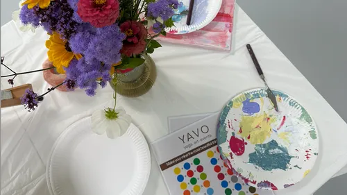 Blumen mit Malutensilien auf einem Tisch.