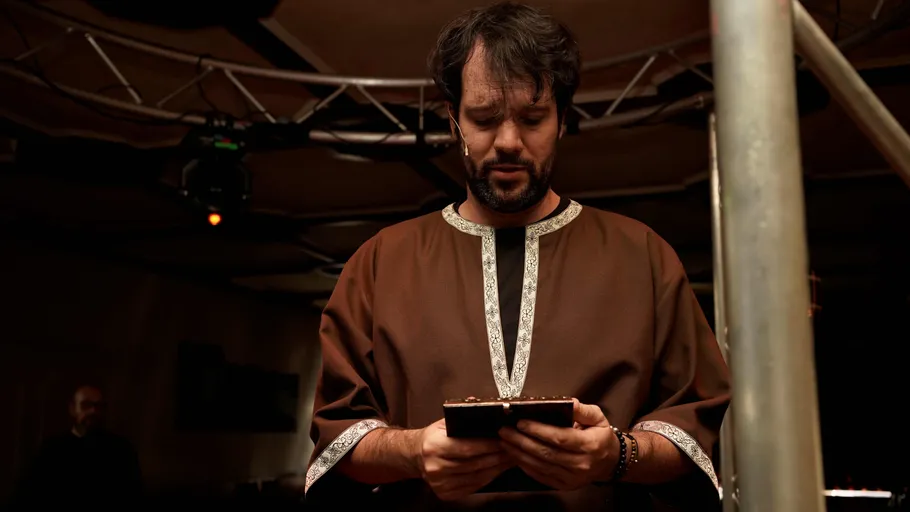 Man reading script in a dimly lit room.
