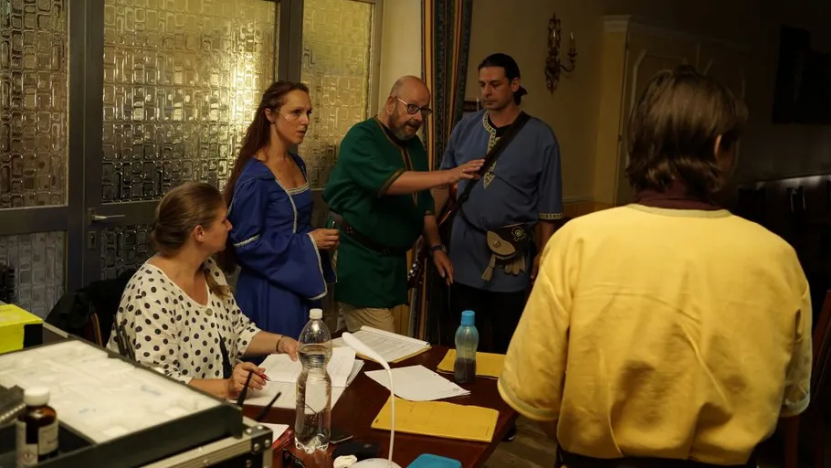 People in medieval costumes discuss at a table.