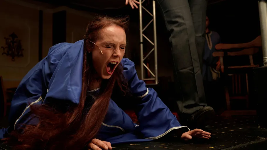 Person im Kostüm ruft auf Bühne.