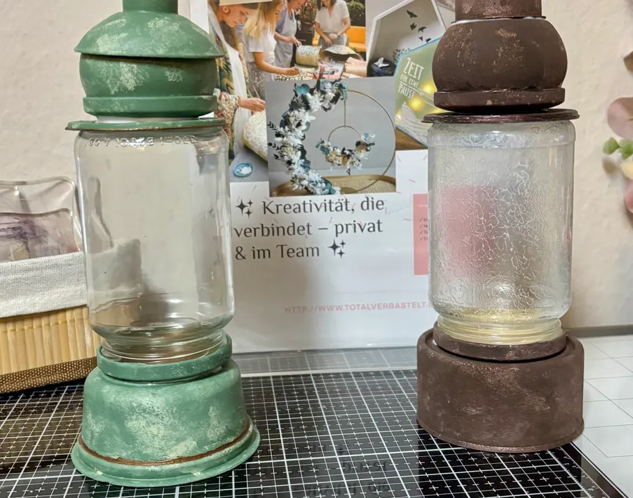 Zwei dekorative Glaslaternen auf einem Tisch.
