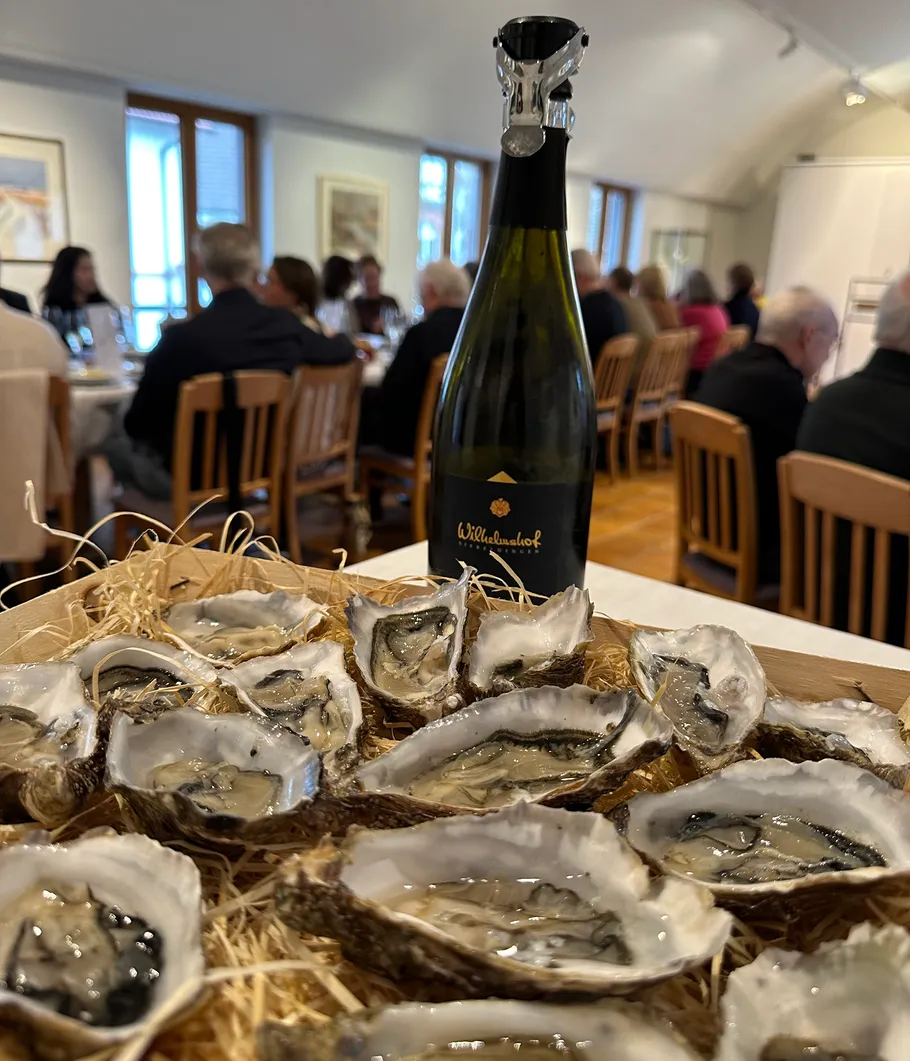 Austern und Weinflasche auf Tisch im Restaurant.
