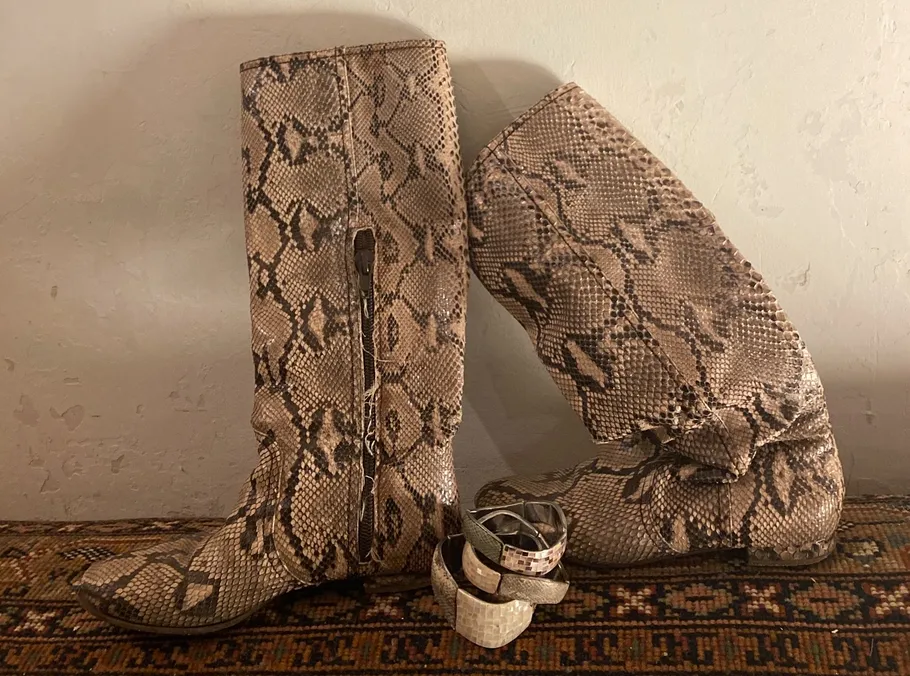 Schlangenmusterschuhe stehen auf einem Teppich.