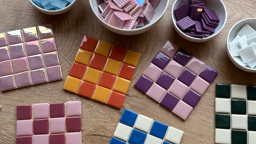 Square tiles and bowls on wooden surface.