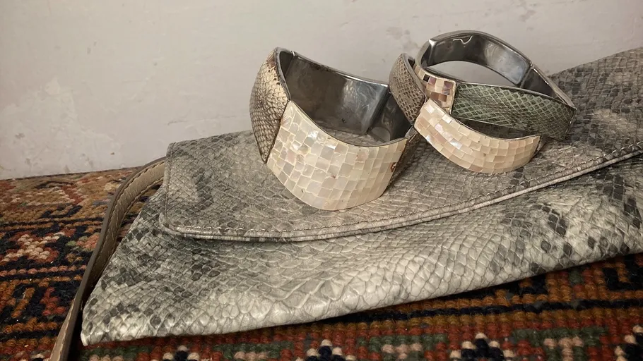 Zwei texturierte Armbänder auf gemustertem Tasche.