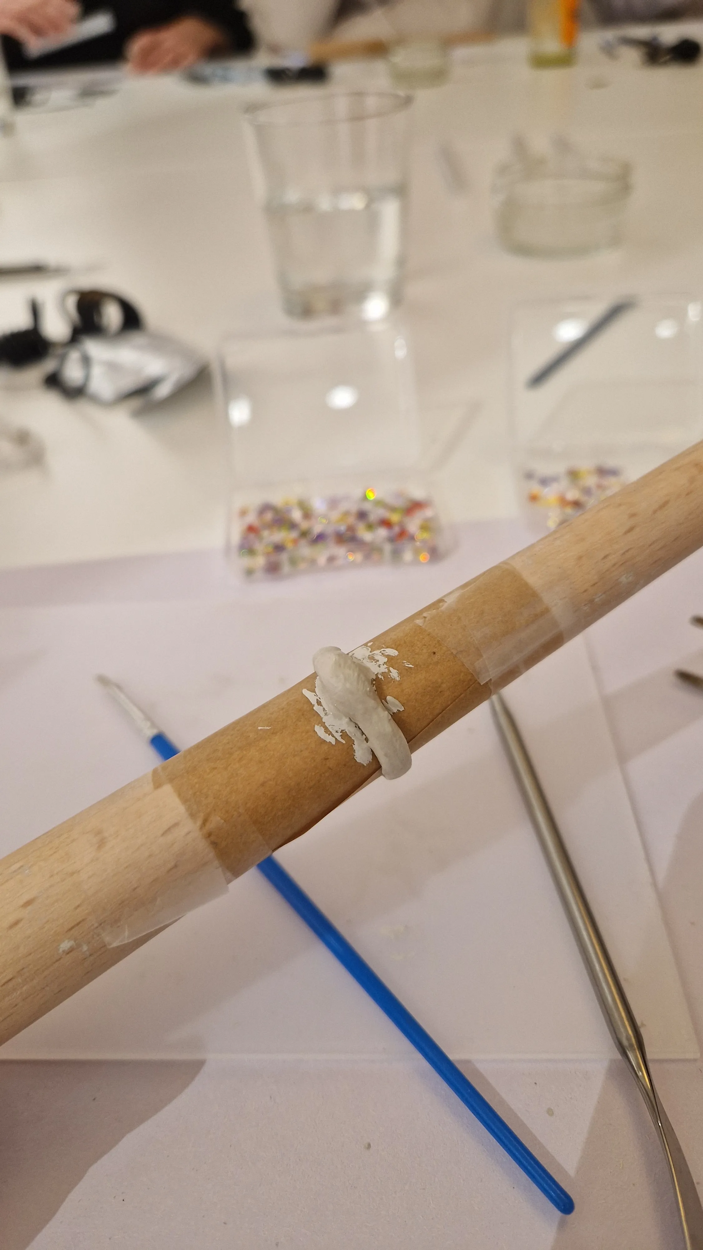 Holzstab mit weißem Kitt in Werkstatt.