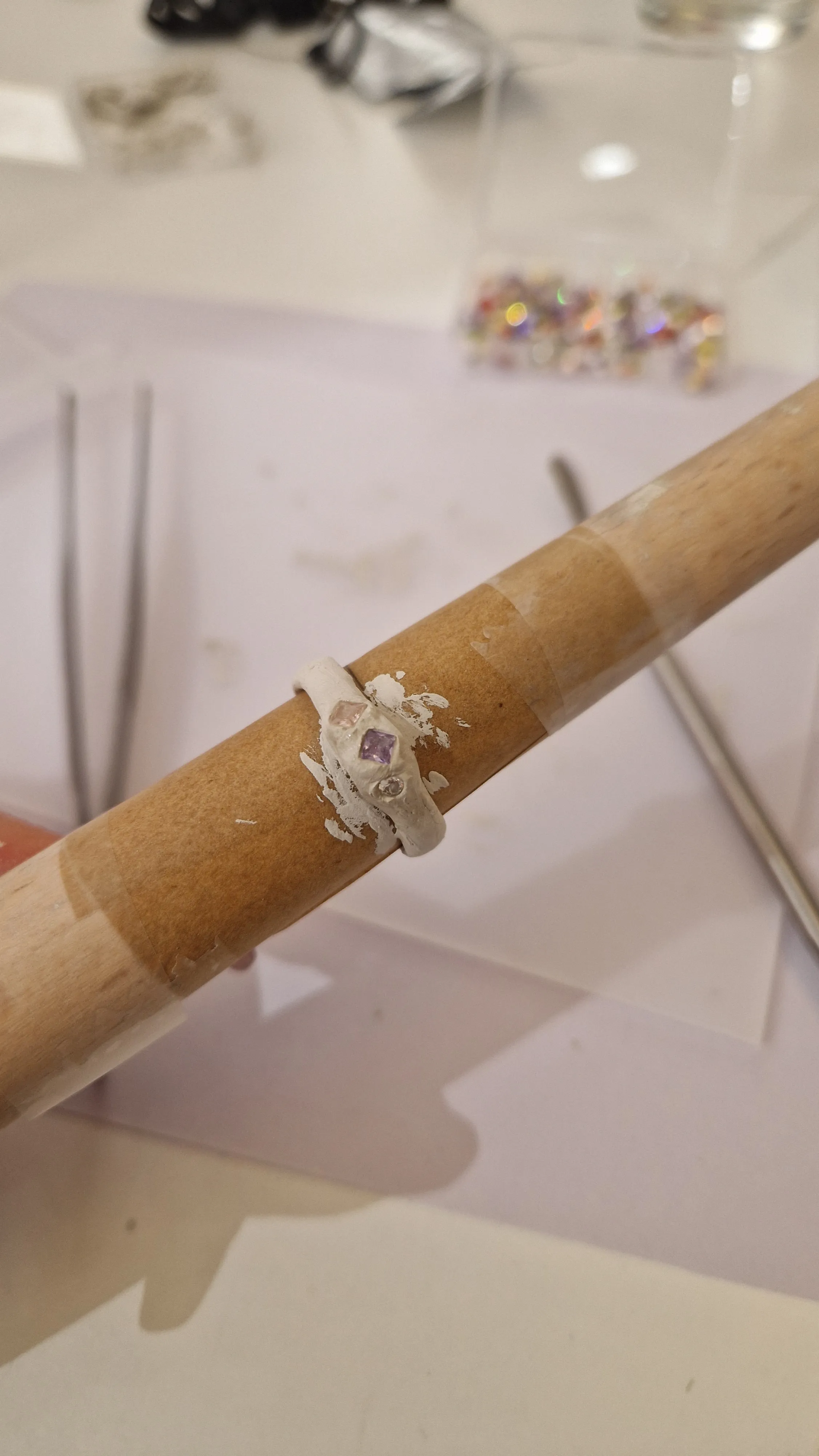 Unvollständiger Ring auf Holzstab, Basteltisch.