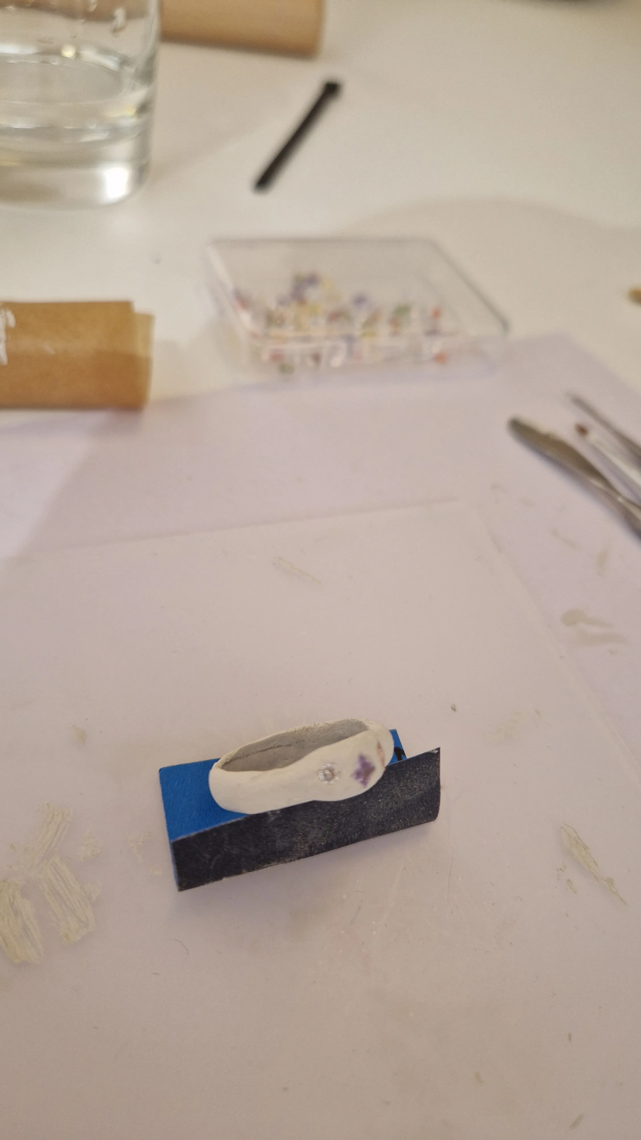 Ring auf Tisch mit Bastelwerkzeugen.