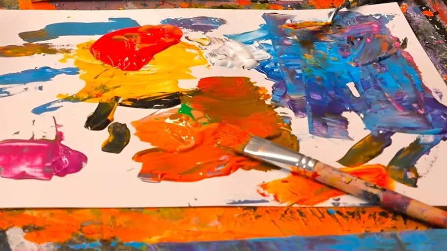 Canvas with colorful paint and brushes.