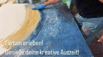 Person painting abstract artwork with blue hues.