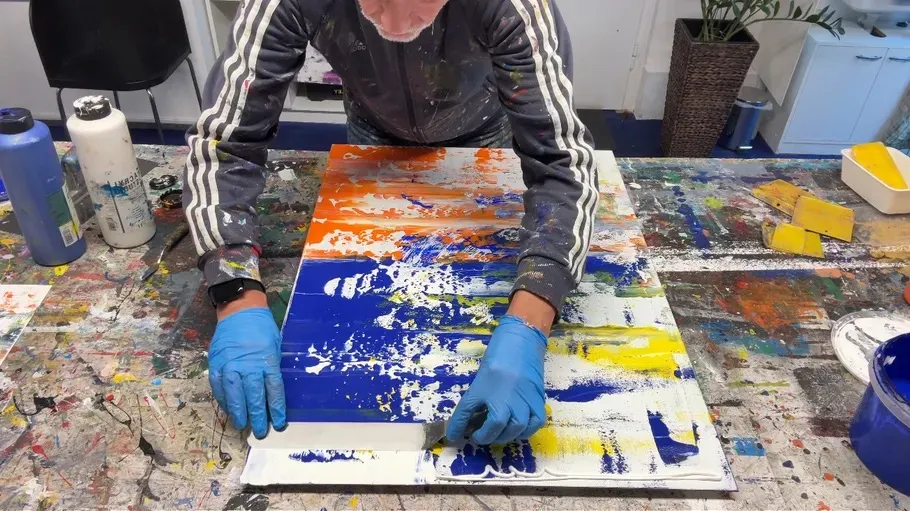Artist painting abstract artwork on canvas.