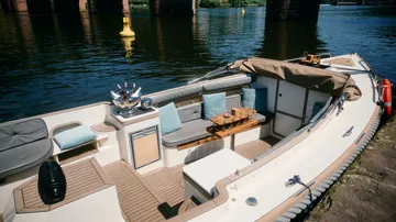 Boot am Flussufer mit Sitzbereich vertäut.