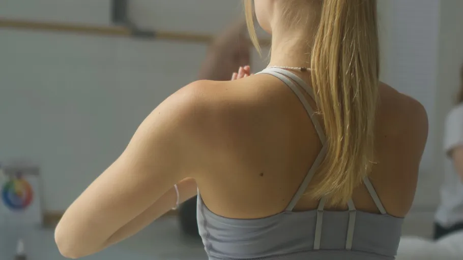 Frau praktiziert Yoga in einem hellen Raum.