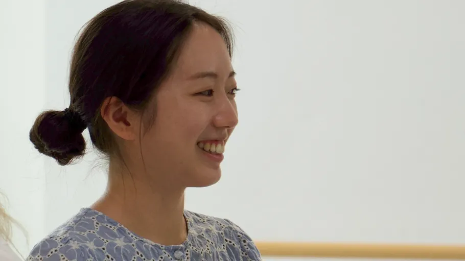 Smiling woman wearing a blue blouse indoors.