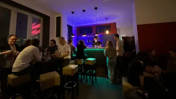 People socializing in a dimly lit bar.