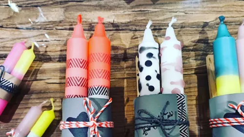 Colorful candles with patterns on wooden surface.