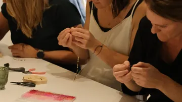 Personen basteln Schmuck an einem Tisch
