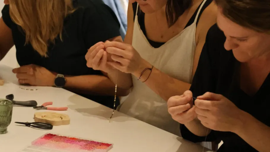 People crafting jewelry at a table