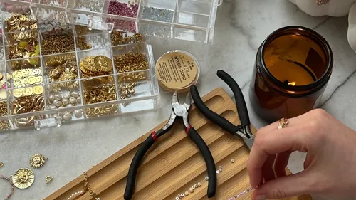 Hand crafting jewelry with beads and tools.