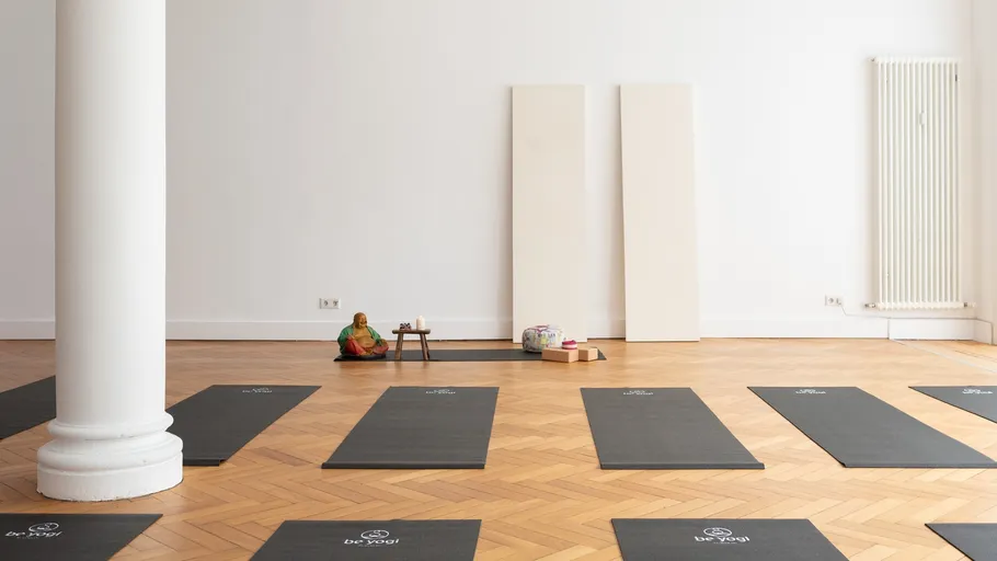 Yoga mats arranged in a spacious room.