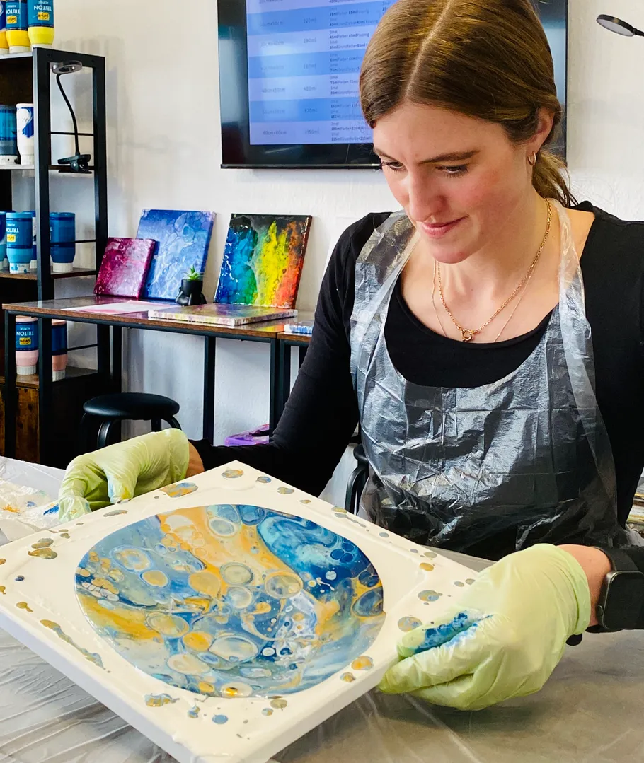 Woman creating abstract art in studio setting.