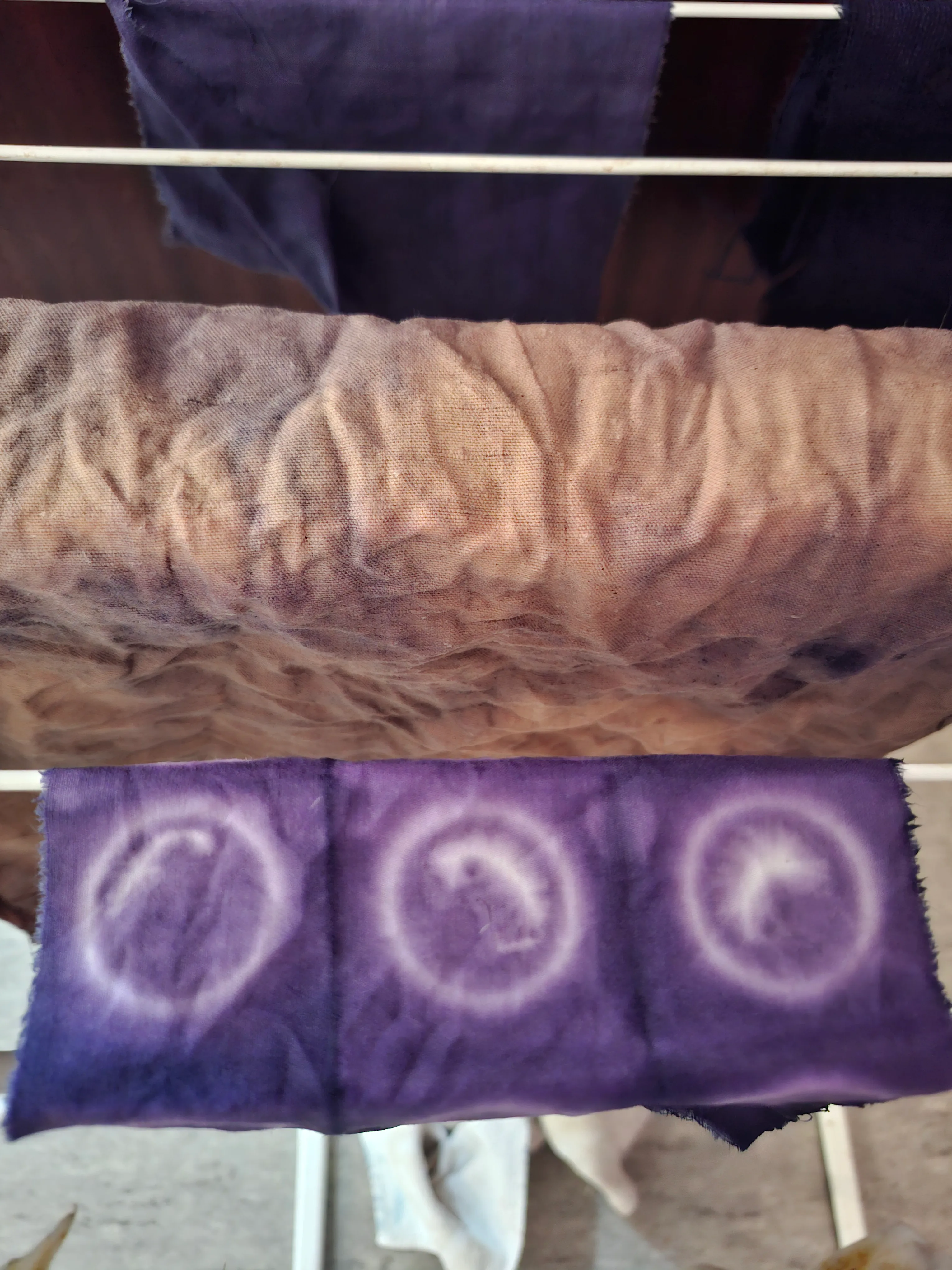Lila Batikstoff trocknet auf einem Gestell.