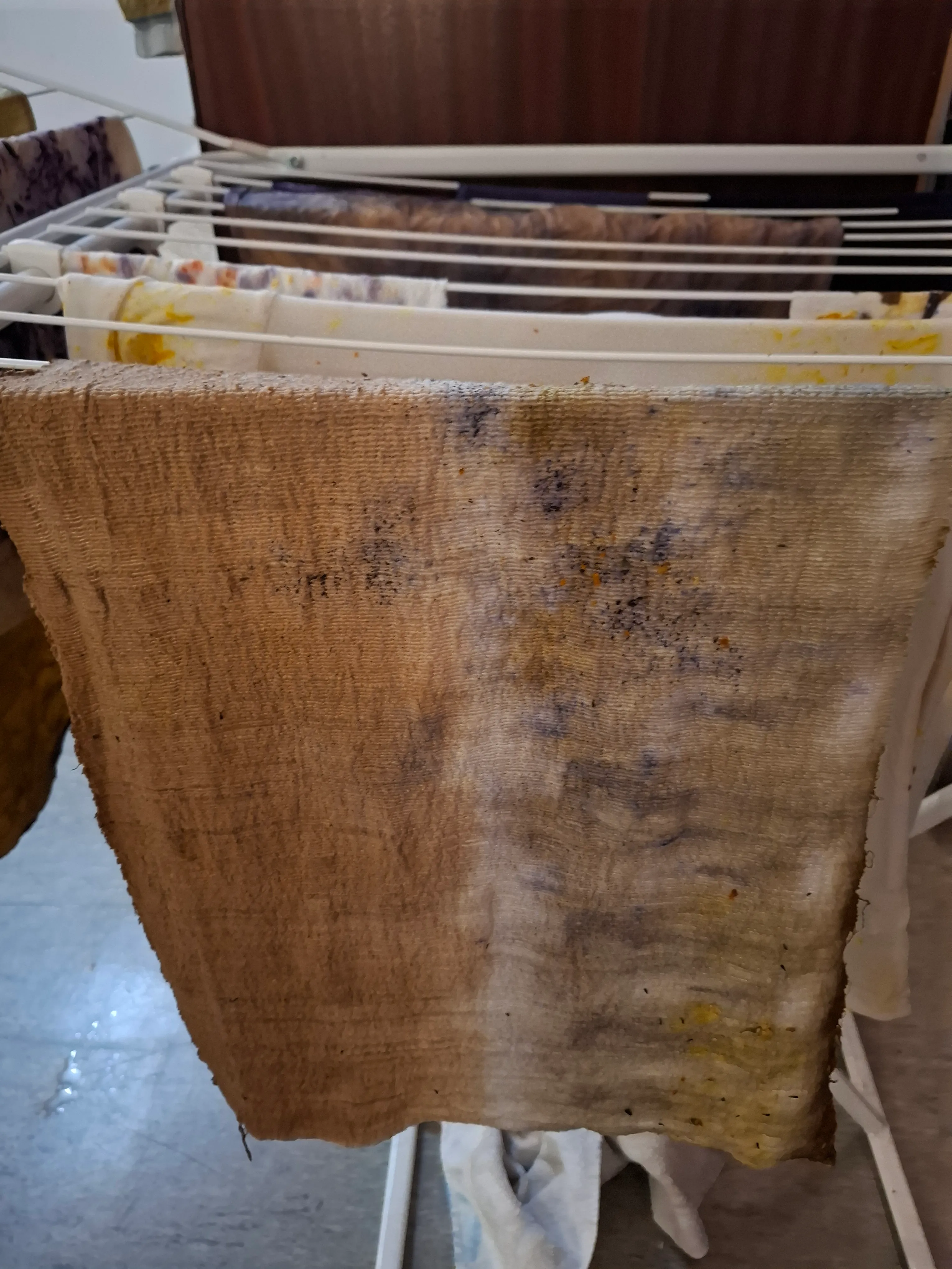 Beflecktes Tuch auf Wäscheständer im Innenraum.