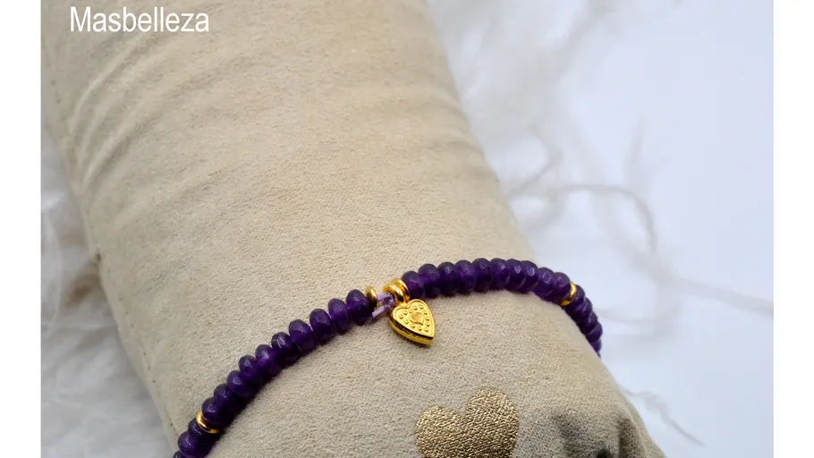 Purple bead bracelet with heart charm displayed.