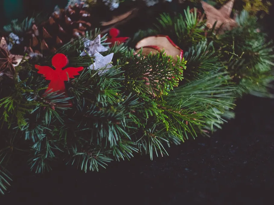 Grüner Kranz mit roten und silbernen Dekorationen.
