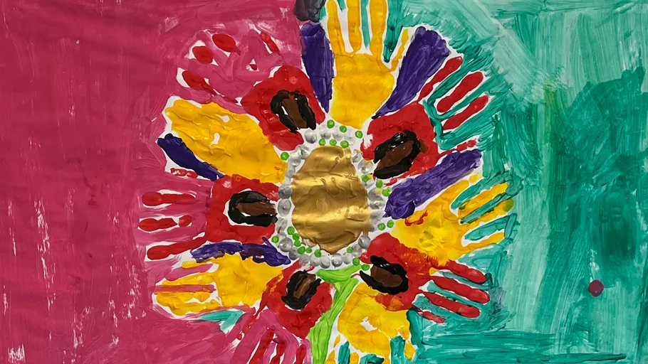 Colorful handprints form flower shape on canvas.